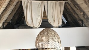A rustic attic room with exposed wooden beams, a hanging light fixture, and a white ceiling. - 3 Bedroom Private vacation home in Saint-Cyprien (Saint-Cyprien)
