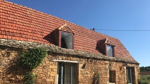 A stone building with a red-tiled roof, two windows, and a door. - 3 Bedroom Private vacation home in Saint-Cyprien (Saint-Cyprien)