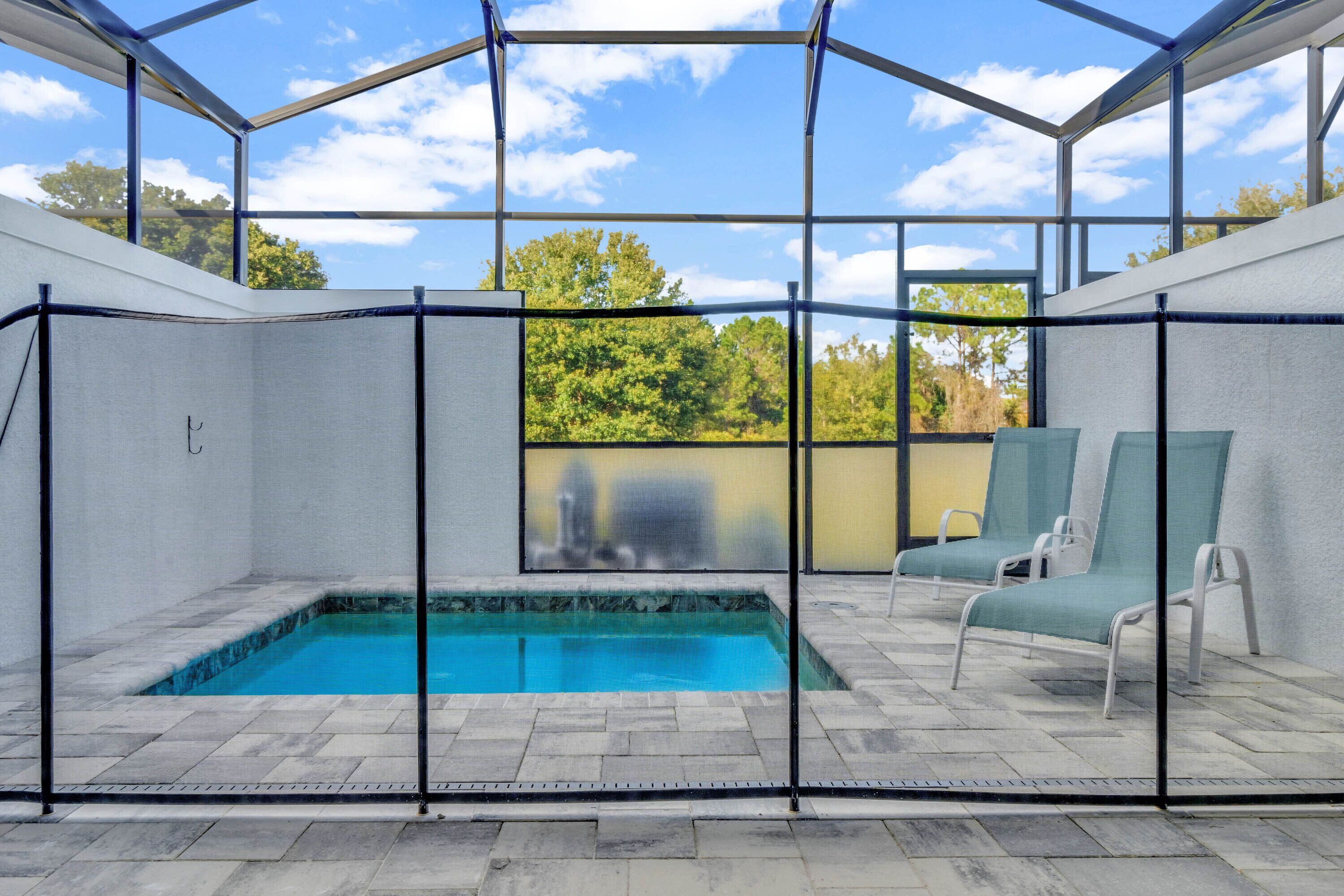 Une piscine extérieure couverte offrant une vue sur les arbres et un ciel dégagé.