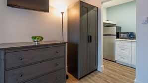 A modern kitchen with a built-in microwave, a refrigerator, and a dark-colored cabinet with drawers. - Moultonborough Inn (Moultonborough)