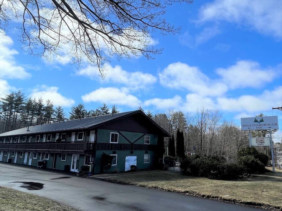 A two-story motel with a green facade and a dark roof.
