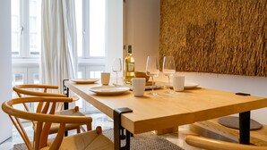 Comedor con una mesa de madera dispuesta para dos personas, una botella de vino y dos copas.