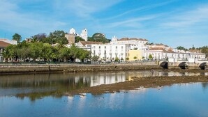 A river with buildings and a bridge in the background. - Residence Apartamento T2 com Piscina (Tavira)