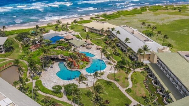 An aerial view of a resort with multiple swimming pools, a beach, and ocean views. - Oceanfront Resort steps to pool/beach via your lanai, 4 Beautiful Pools (Lihue)
