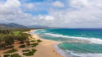 Na praia, espreguiçadeiras, toalhas de praia