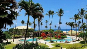 A resort with multiple swimming pools, palm trees, and a view of the ocean. - Oceanfront Resort steps to pool/beach via your lanai, 4 Beautiful Pools (Lihue)