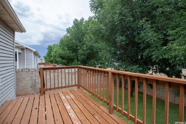 Enjoy outdoor activities on this spacious deck with a grassy lawn and tree-lined view.