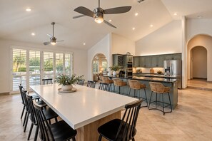 A spacious kitchen with a central island, bar stools, and modern appliances.