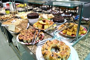 Un bufé con diversas opciones de panadería y postres.