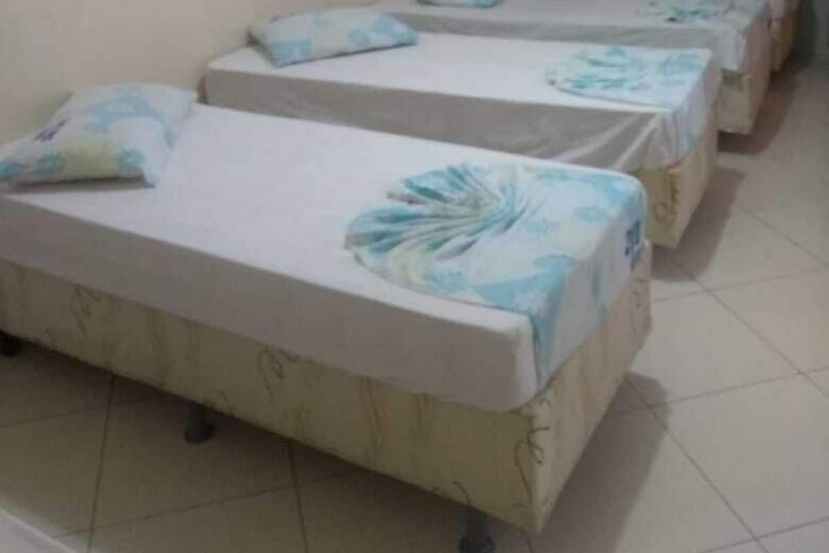 Un dormitorio con cuatro camas individuales, cada una con un cubrecolchón estampado con motivos florales.