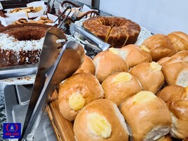 Un bufé con diversas opciones de repostería, incluyendo pasteles, bollos y productos de pastelería.