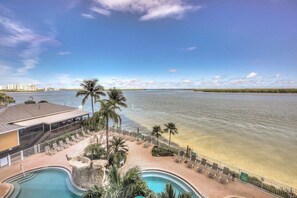 A resort with a pool, beach area, and a view of the water. - Southern Comfort in Bonita Springs (Fort Myers Beach)