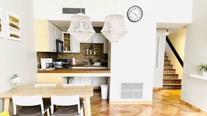 A modern kitchen with white cabinets, a wooden countertop, and two hanging light fixtures. - Oceanview Villa - Steps Away from the Beach / Palmas del Mar Resort. (Palmas del Mar)