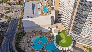 A hotel with a rooftop pool, a circular pool, and a large building with a curved facade.