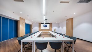 A conference room with a long table, multiple chairs, and a screen at the front. - Holiday Inn Express Linzhi Airport by IHG (Nyingtri)