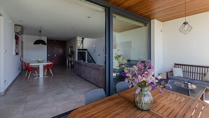 A modern living space with a dining area, a sofa, and a wooden table with a vase of flowers. - YourHouse Casa Llubi,  house with private pool and air conditioning (Llubi)