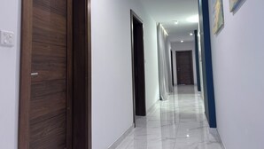 A hallway with wooden doors and white walls, leading to multiple rooms. - Mediterranean Breeze Apartment (Xaghra)
