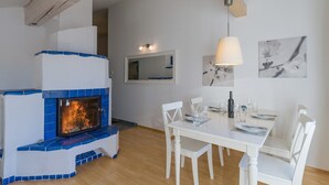 A room with a fireplace, white furniture, and artwork on the walls. - Ski-in / Ski-out (Kirchberg in Tirol)