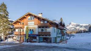 A multi-story hotel with a ski service shop, surrounded by snow and mountains. - Ski-in / Ski-out (Kirchberg in Tirol)