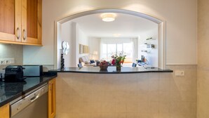A kitchen with wooden cabinets, a dishwasher, and a countertop.