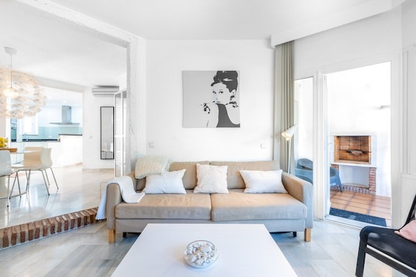A modern living room with a sofa, a coffee table, and a large window.