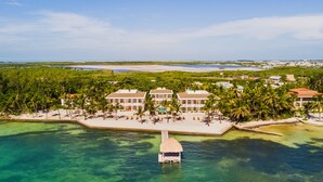 An aerial view of a resort with multiple buildings, a beach, and a water dock. - Tara Del Sol (San Pedro)