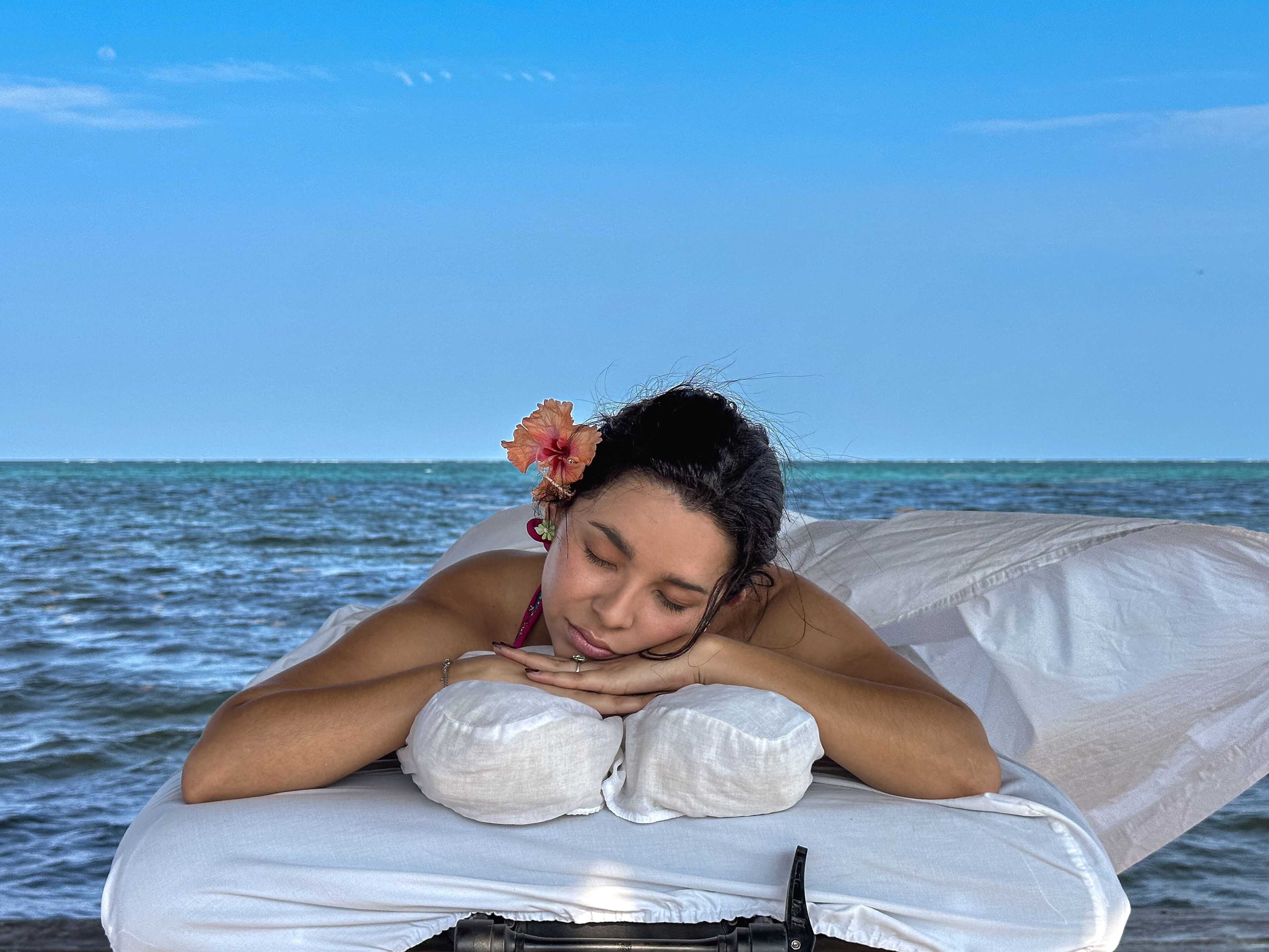 Iemand ligt in bed met uitzicht op de oceaan.