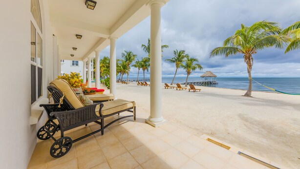 A covered terrace with a view of the beach, palm trees, and ocean. - Tara Del Sol (San Pedro)