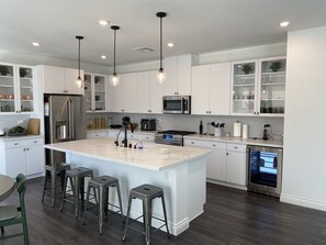 Enjoy cooking in this well-equipped kitchen with a central island, stainless steel appliances, and ample cabinetry.