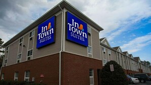 A hotel with a sign reading "In Town Suites." - InTown Suites Extended Stay Richmond VA - Midlothian (Richmond)