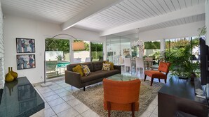 A modern living room with a glass dining table, a sofa, and a TV stand. - NEW!!! The Cosmo. A mid-century gem in the desert (Palm Springs)