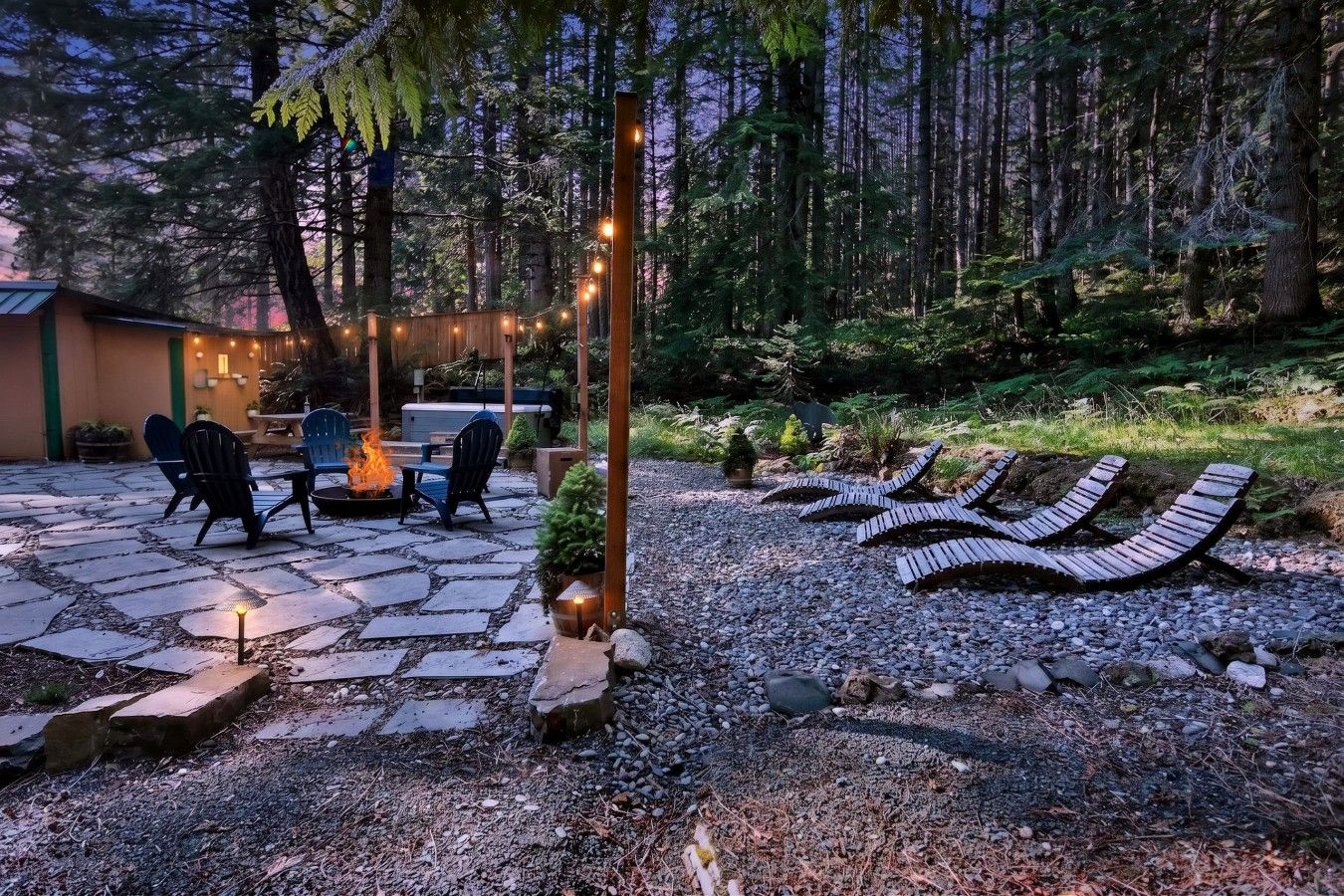 Una zona patio con pavimento in pietra, posti a sedere all'aperto e un elemento decorativo a fuoco.