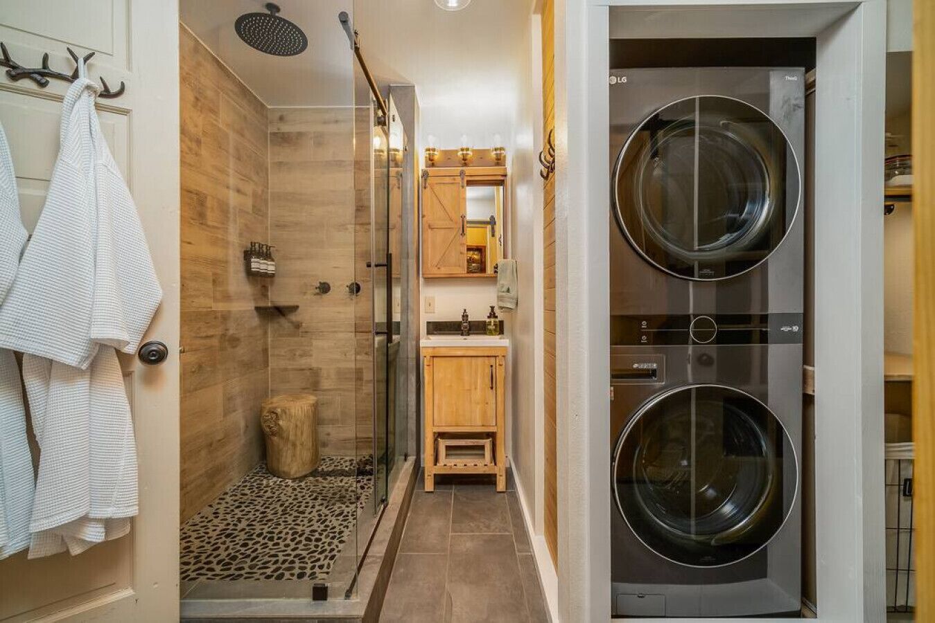 Un baño pequeño con ducha, lavamanos y lavadora doble.