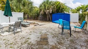 Ein Garten mit Pool, Gartenmöbeln und Palmen.