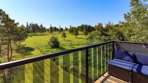 Un balcon avec vue sur un terrain de golf.