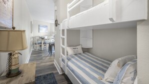 A bunk bed room with a desk and chair in the background. - Live Like a Local Too (Miramar Beach)