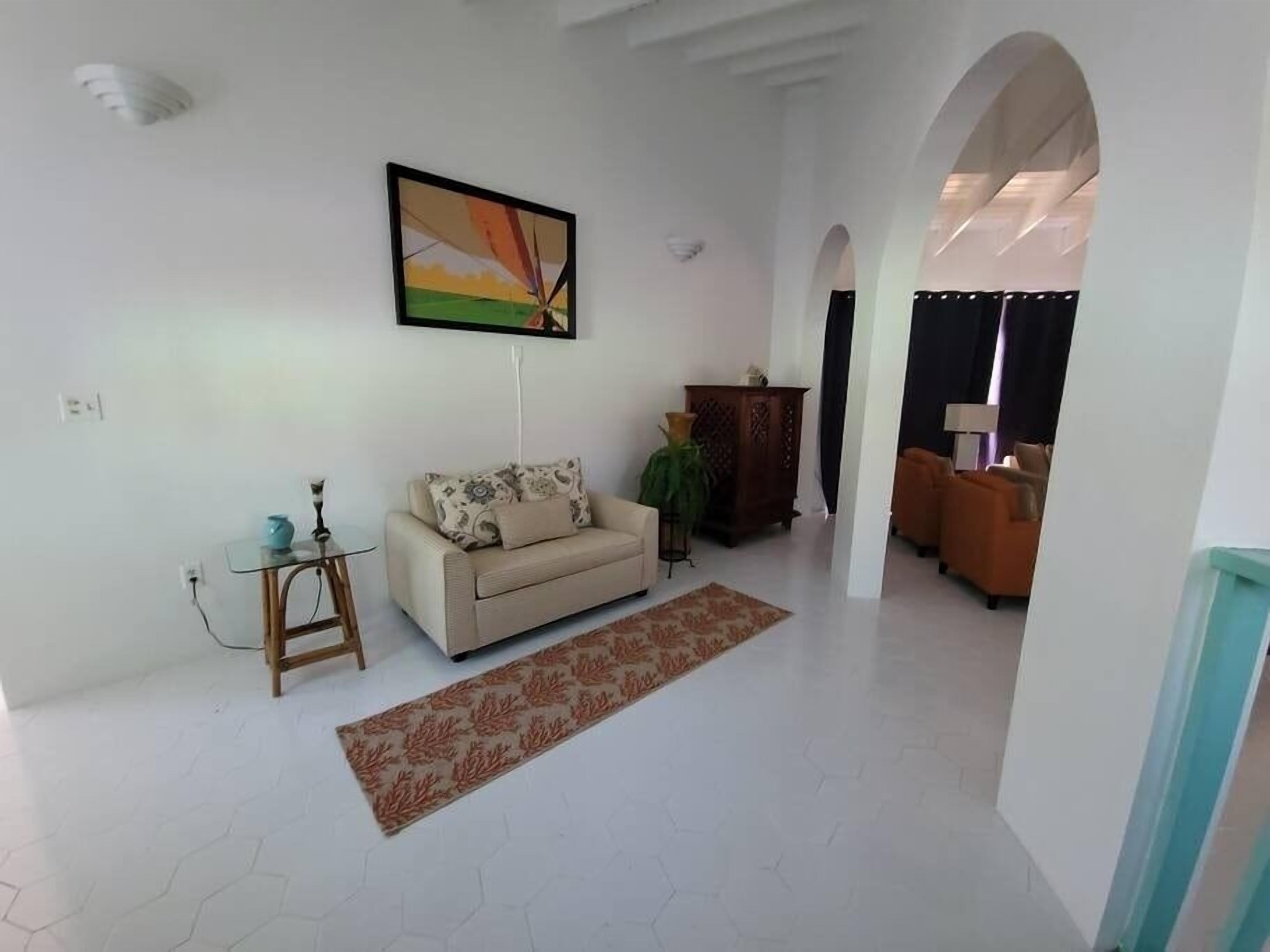 Ein Wohnzimmer mit einer Couch, einem Couchtisch und einem Bild an der Wand.