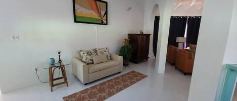 Ein Wohnzimmer mit einer Couch, einem Couchtisch und einem Bild an der Wand.