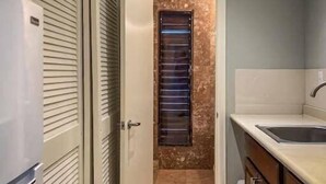A kitchen with a refrigerator, cabinets, a sink, and a window with blinds. - Blue Horizon, One - Walk to beach & Restaurants. (East End)