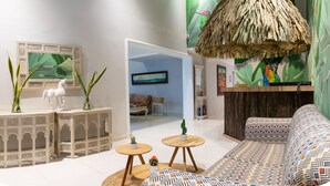 A modern living room with a sofa, a coffee table, and decorative plants. - Casa Chunuu hotel boutique (Santa Marta)