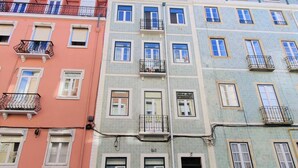 Un immeuble à plusieurs étages doté de balcons, de fenêtres et d’une porte.