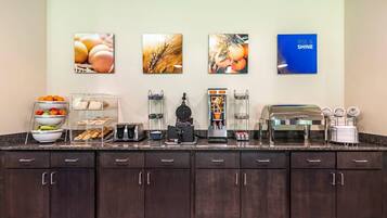 Una barra de desayuno con diversas opciones de comida y una estación de café.