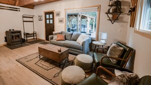 A cozy living room with a sofa, ottomans, a coffee table, and a fireplace.