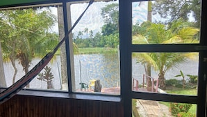 Una habitación con vista a una masa de agua, un letrero de salida y una hamaca.