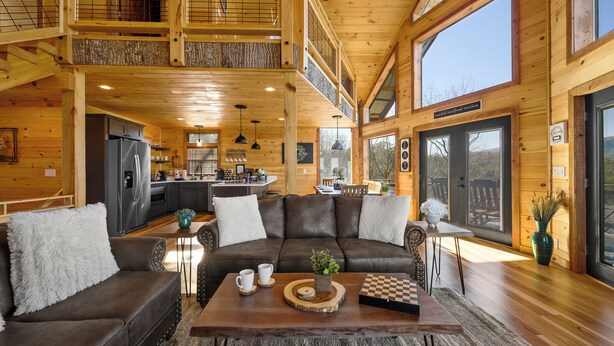 A spacious wooden cabin with a living area featuring a sofa, coffee table, and a chess set. - BeautifulMtViewResortIndoorPool/Spa2CabinsPFNearIsland/Strip Game Room 16-18ppl (Pigeon Forge)