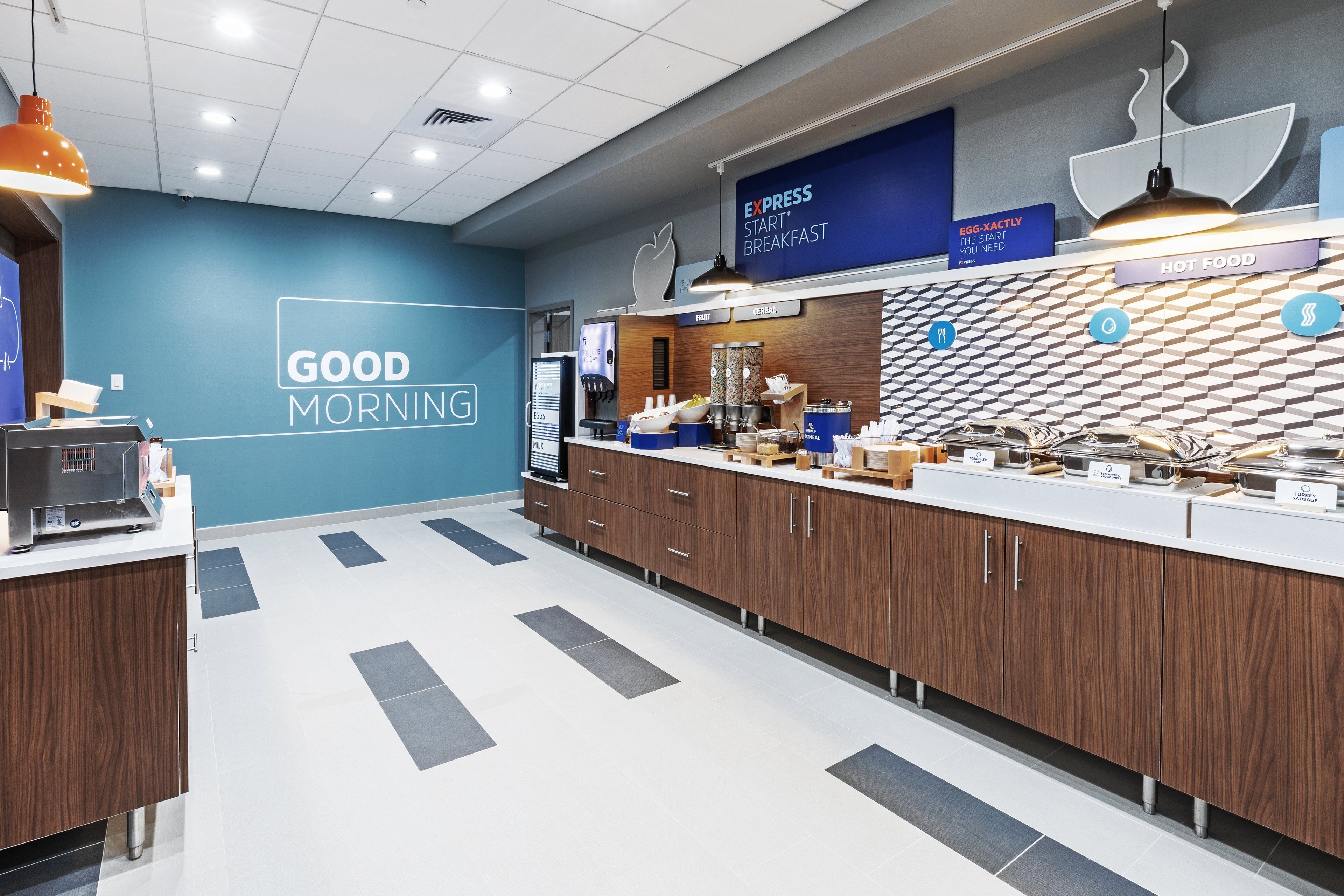 A breakfast area with a blue wall, a sign reading "GOOD MORNING", and a counter with various food items.