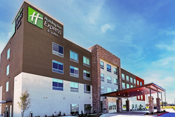 Un edificio de Holiday Inn Express de diseño moderno, con múltiples ventanas y un acceso cubierto.