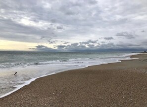 Une plage de galets, avec des vagues.