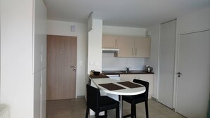 Uma cozinha compacta com mesa e cadeiras, fogão e armários.