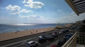 Una strada lungo la spiaggia con auto, una spiaggia e cielo sereno.